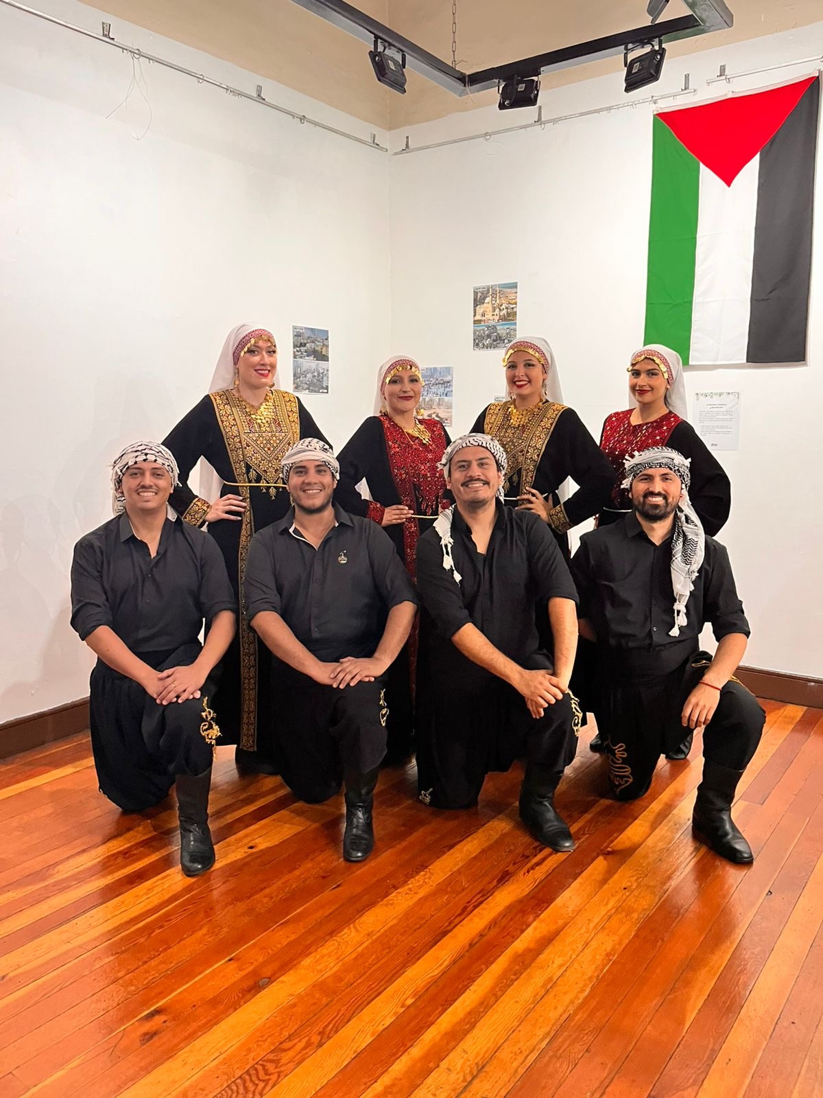 Al Ard al Baiida members posing with the Palestinian flag