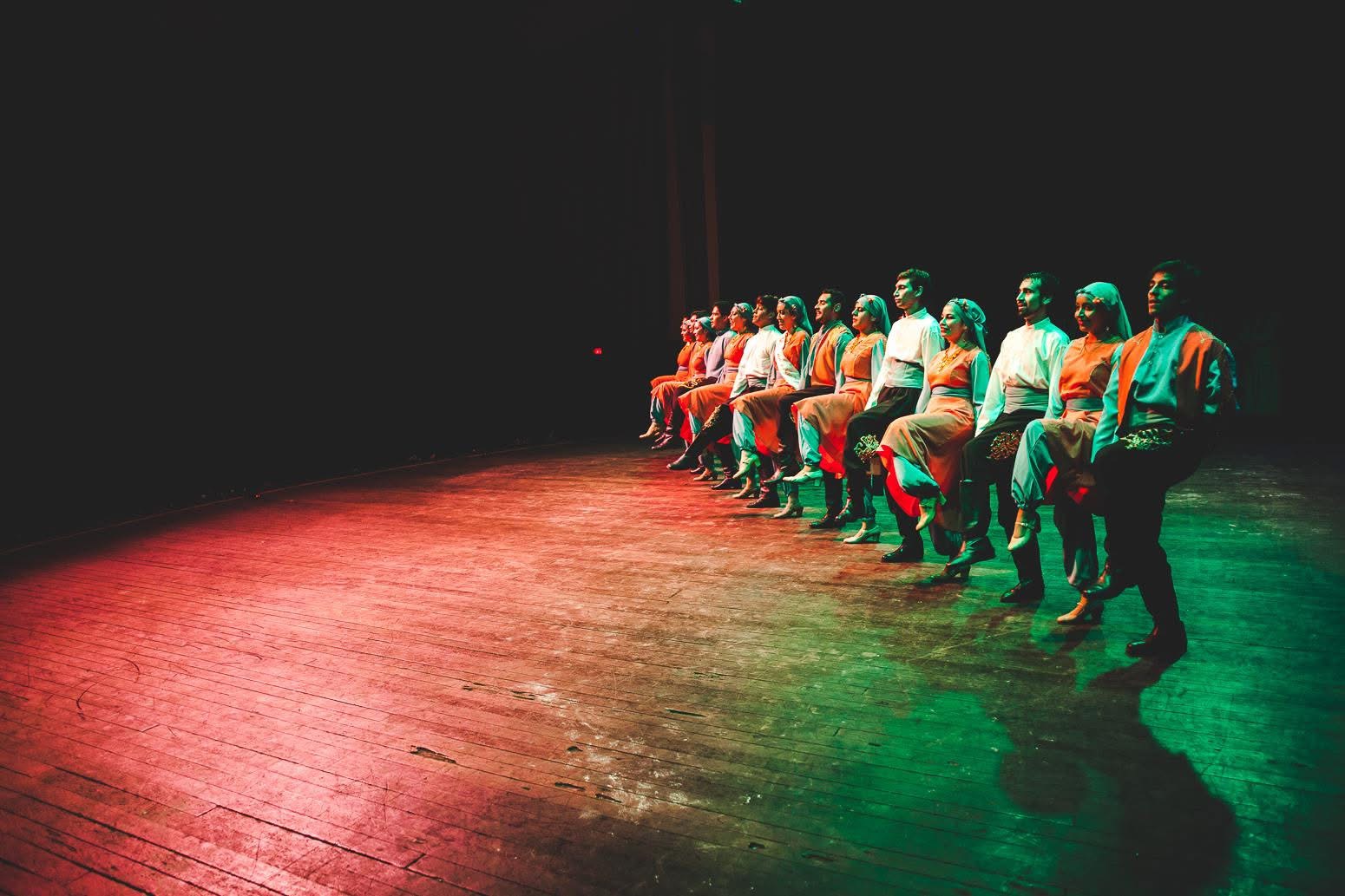Al Ard al Baiida cast in formation during a theater performance